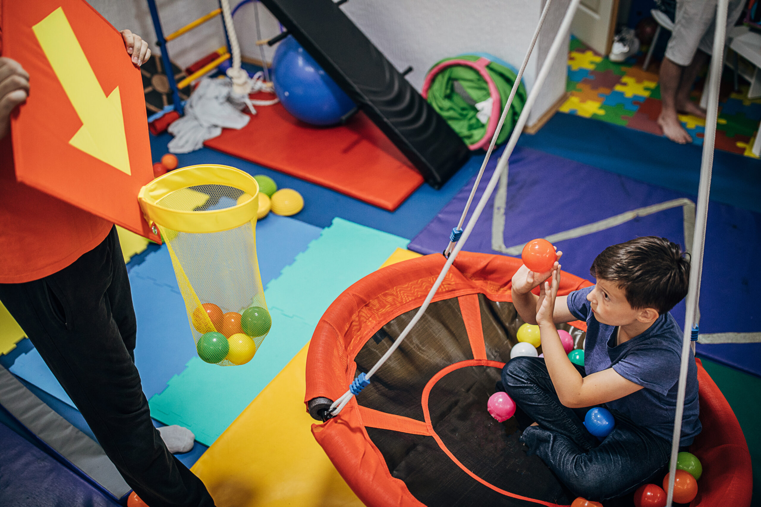 Two people, male physical therapist and boy on physiotherapy, improving sensory perception.